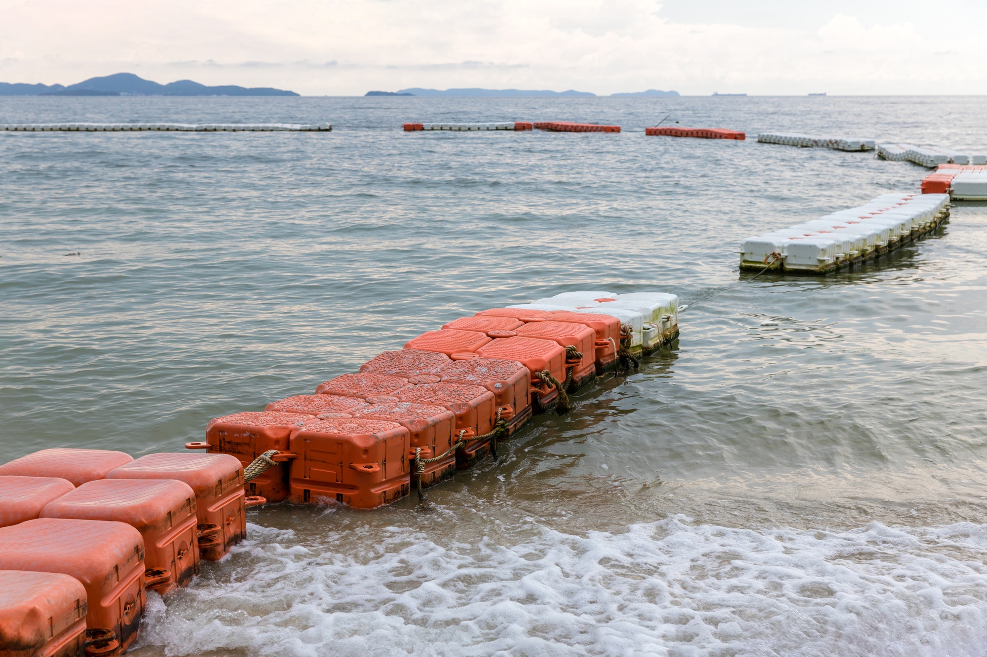 Polystyrene buoy on the sea surface. floating buoys and rope dividing area on the beach.